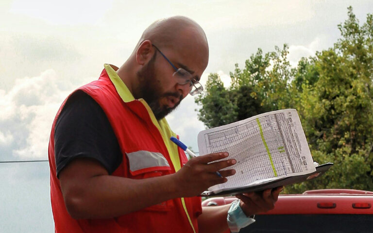 Male construction working looking at papers reviewing safety information.